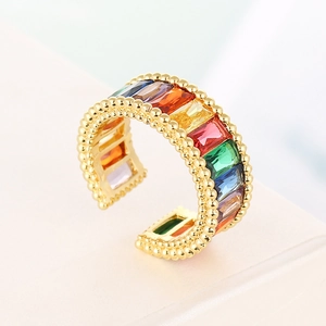 Detailed macro view of gold-plated open ring with rainbow zircon stones and beaded edges
