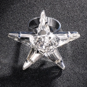 Chic star-shaped crystal open ring with sparkling facets on a dark textured background