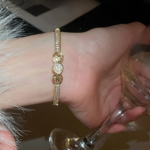 Macro shot of 18K gold plated zircon cuff bracelet with intricate geometric hollow design