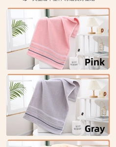 Dettaglio di asciugamani in cotone rosa e grigio con strisce in un ambiente da bagno