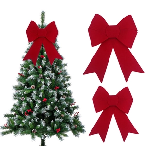 Large red flocked velvet Christmas bow decoration shown on a tree and white background