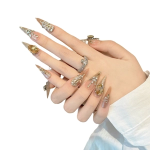 Unghie finte di lusso color champagne con forma stiletto e decorazione con gemme 3D