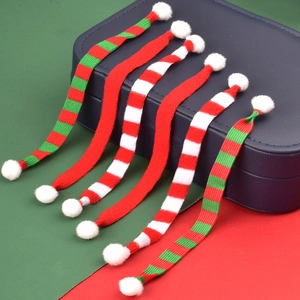 Nahaufnahme bunter Weihnachts-Mini-Strickschals mit weißen Pompons für Dekorationen