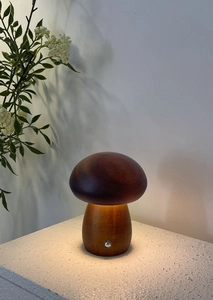 Detail view of wooden mushroom lamp base featuring the metal touch switch on white texture