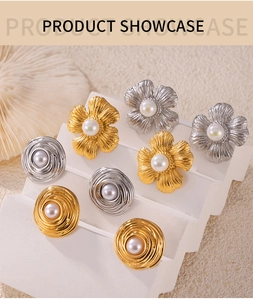 Detail of vintage flower and spiral stud earrings with pearls in gold and silver finish