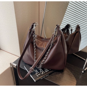 Detailed view of deep brown faux leather hobo bag with dual-tone metal chain straps