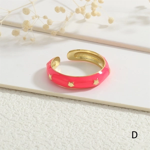 Detail of a pink enamel gold-plated adjustable ring featuring engraved golden star patterns