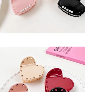 Detailed view of heart-shaped acetate hair claws with pearls and rhinestones decoration