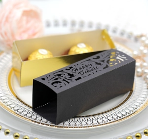 Detail der lasergeschnittenen Happy Diwali Pralinenschachtel mit goldenem Einsatz auf Teller