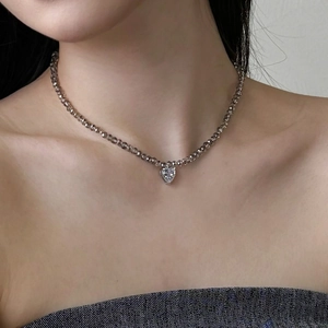 Close-up of S925 silver necklace with brown faceted beads and a heart crystal pendant