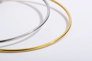 Close-up of minimalist gold and silver expandable heart bracelets with polished finish