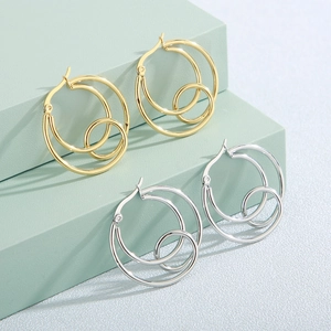 Polished gold and silver geometric multi-layer knotted hoop earrings on display