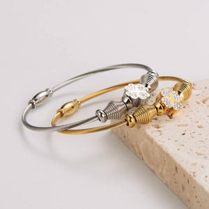 Elegant stainless steel wire bangle with clover charm in gold and silver finish