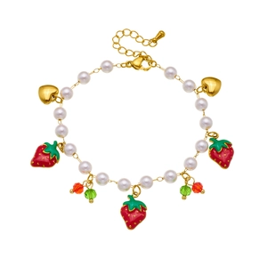 Sweet fruit pearl bracelet with strawberry charms and gold hearts on a white background
