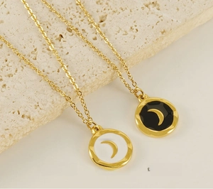 Detail of 18K gold-plated stainless steel moon pendant necklace with enamel