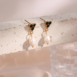 Detail of 18K gold earrings featuring three green gems and a natural white pearl drop