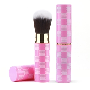 Macro view of portable retractable powder brush with pink checkered case and soft bristles