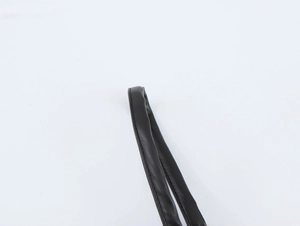 Détail d'une bandoulière en cuir PU noir avec coutures fines et texture grainée