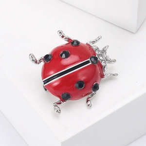 Detailed close-up of a red ladybug brooch with enamel finish and sparkling crystal accents