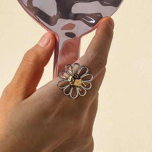 Elegant gold and silver daisy flower stainless steel ring worn on index finger