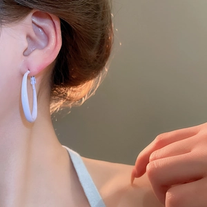 Close-up of minimalist silver hoop earring on model showing smooth finish and elegant style