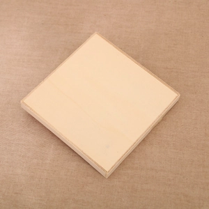 Macro shot of square wooden ornaments featuring smooth natural grain on textured beige cloth