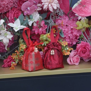 Detail of red jacquard silk wedding candy bag with gold double happiness pendant