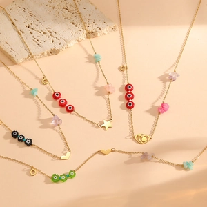 Detail of bohemian gold necklaces with colorful heart, star, and evil eye charms