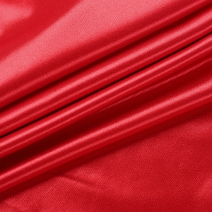 Macro shot of red satin fabric showing smooth texture and elegant light reflection