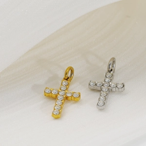 Détail macro de pendentifs croix en acier inoxydable or et argent avec zircons