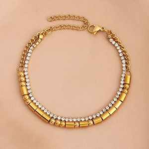 Detailed close-up of gold-plated double-layer bracelet with crystals on silk background