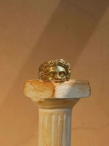 Detailed relief of Venus facial sculpture on a vintage gold metal open ring
