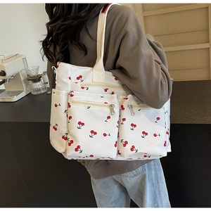 Canvas tote bag with cherry print showing side view and multiple zipper pockets