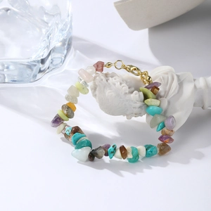 Close-up of bohemian colorful natural gemstone beads on a white artistic sculpture