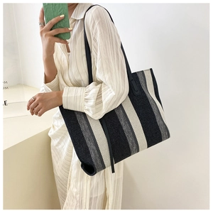 Detailed close-up of thick knitted vertical stripes on a large capacity tote bag