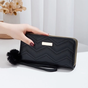 Black long women's quilted wallet with double zippers, gold hardware and pompom keychain