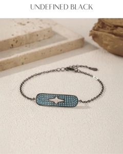 Detail of black metal chain bracelet with star motif and blue turquoise inlay stones