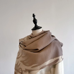 Close-up detail of soft knitted brown and beige cashmere-like scarf texture on a mannequin