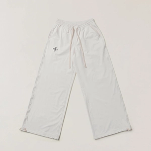 Detail of adjustable drawstring waistband on cream loose wide-leg sport trousers