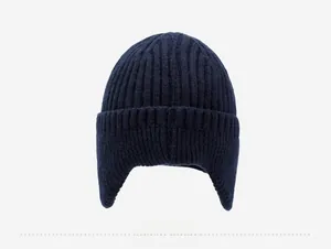 Rear view of a dark blue knitted winter beanie with thick earflaps and striped texture