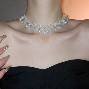 Detail of elegant French vintage choker featuring hand-woven pearls and fringe pendants