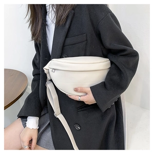 Close-up of cream PU leather chest bag on model showing texture and minimalist design