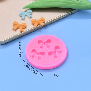 Pink silicone round mold with 3 bow tie shapes for fondant cake decorating and DIY crafts