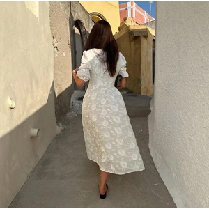 Vue détaillée du dos de la robe midi blanche avec broderie florale et manches bouffantes