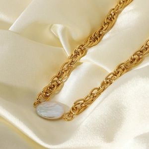 Detailed view of 18K gold plated chain necklace with a flat baroque pearl on white satin