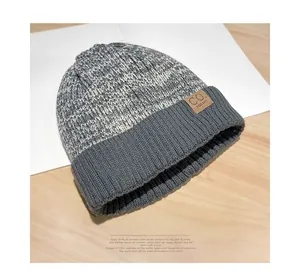 Detailed knit texture and brown leather label on thick gray winter beanie hat