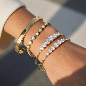 Stack of four 18k gold plated stainless steel bangles with zircons on a model wrist
