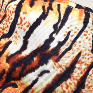 Macro shot of tiger print fabric with orange and black stripes and twill weave details