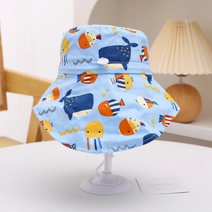 Detail of baby sun hat featuring blue whale prints and adjustable white chin strap