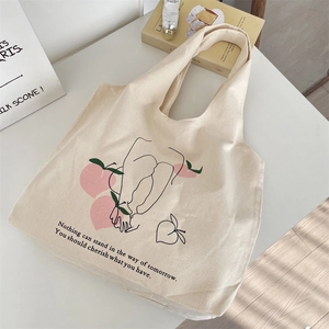 Detailed shot of beige canvas tote bag with minimalist peach and line art illustration